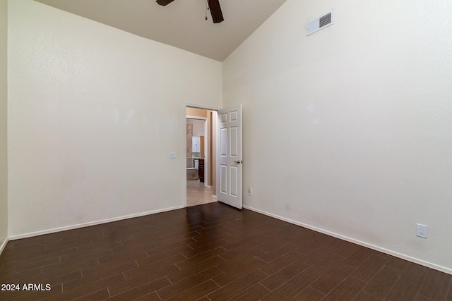 spare room with dark hardwood / wood-style flooring, high vaulted ceiling, and ceiling fan