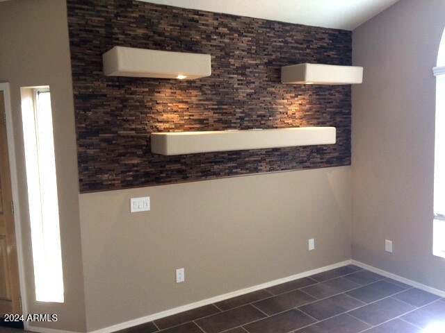 empty room with dark tile patterned flooring