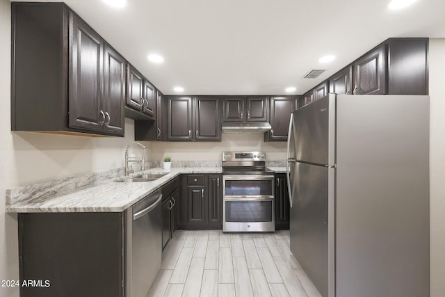 kitchen with recessed lighting, under cabinet range hood, stainless steel appliances, a sink, and visible vents