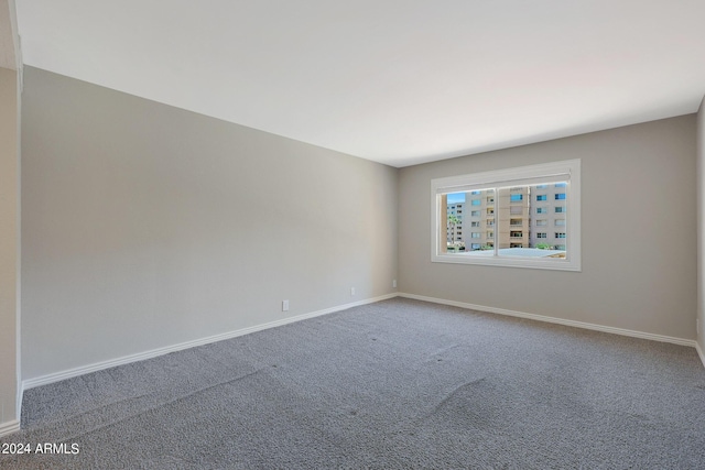 carpeted spare room with baseboards