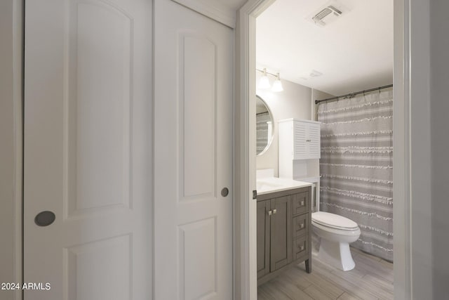 bathroom with toilet, a shower with shower curtain, vanity, and visible vents