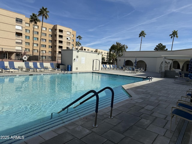 community pool with a patio and fence