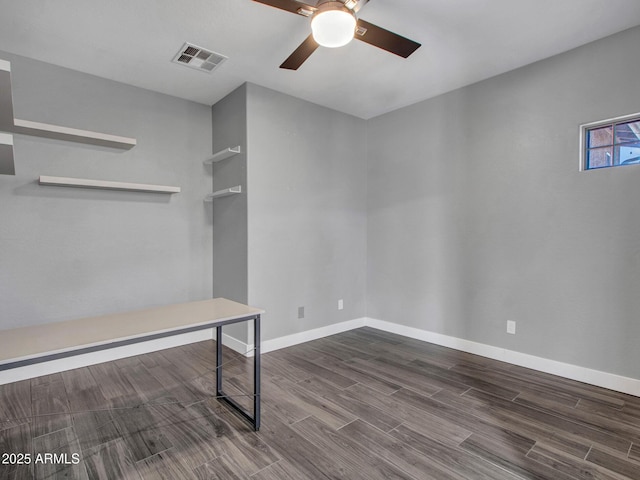 unfurnished office featuring a ceiling fan, visible vents, baseboards, and wood finished floors