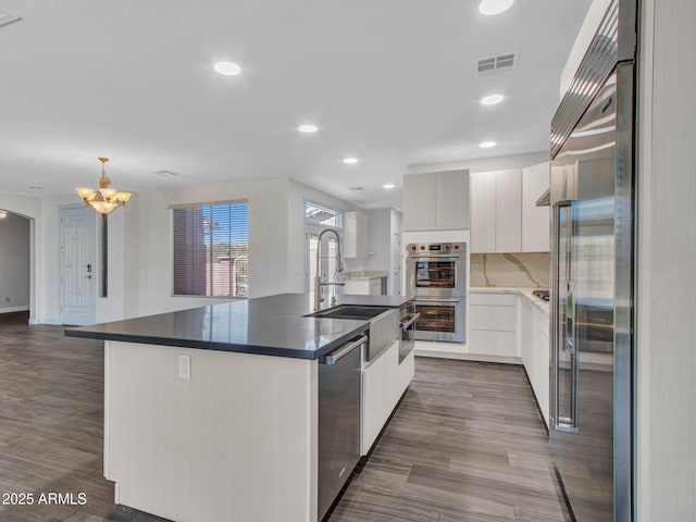 kitchen with appliances with stainless steel finishes, visible vents, a sink, and modern cabinets