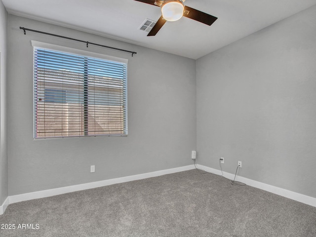 empty room featuring carpet floors, visible vents, and baseboards