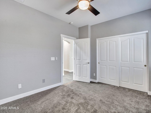 unfurnished bedroom featuring a closet, carpet flooring, a ceiling fan, and baseboards