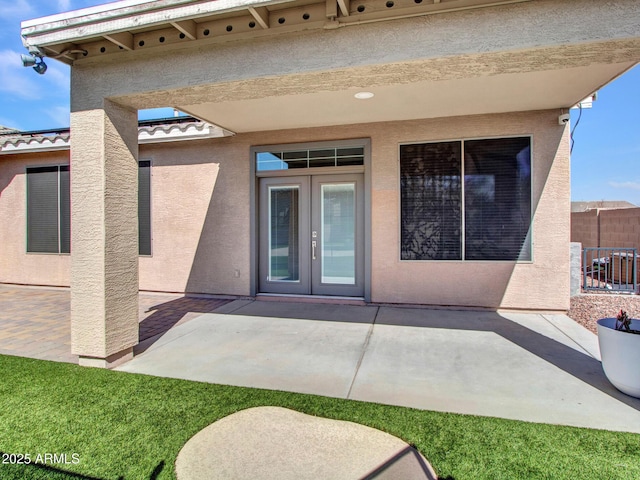 exterior space with a patio, a tiled roof, fence, french doors, and stucco siding