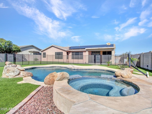 view of swimming pool featuring a pool with connected hot tub, a fenced backyard, and a yard