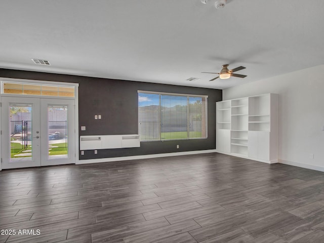 unfurnished living room featuring dark wood-style floors, french doors, visible vents, and baseboards