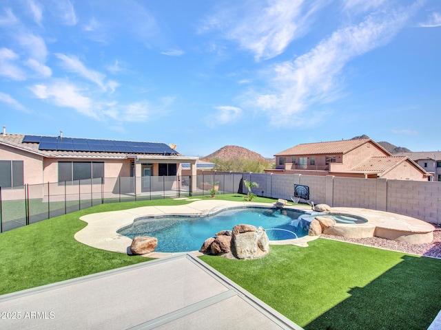 view of pool featuring a pool with connected hot tub, a fenced backyard, a mountain view, and a yard