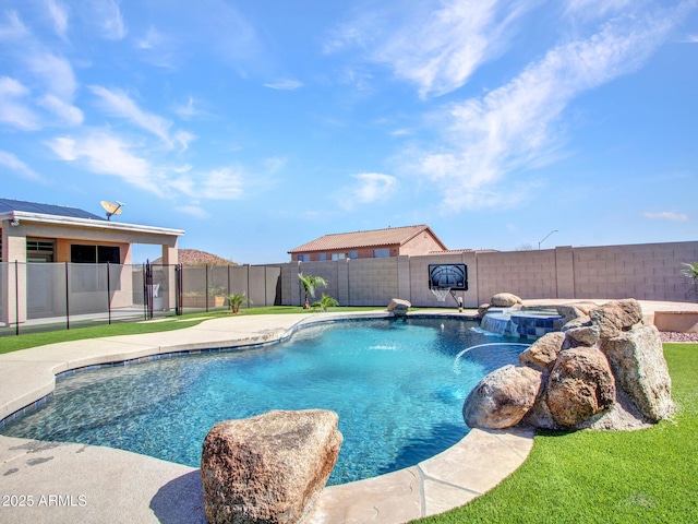 view of pool with a fenced backyard and a pool with connected hot tub