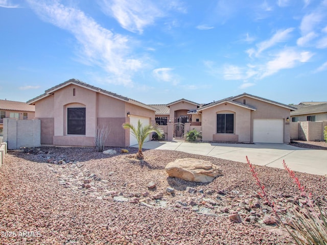 view of front of property featuring a garage, concrete driveway, fence, and a gate