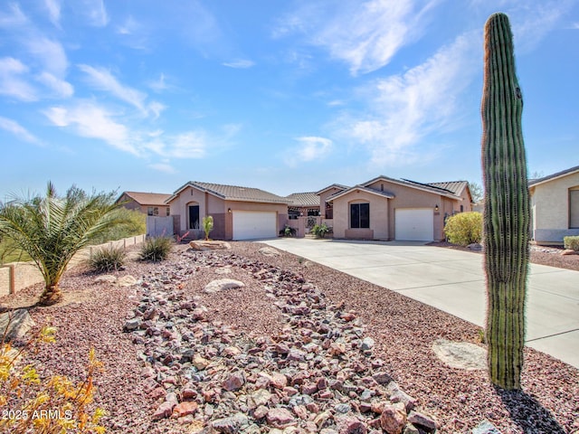 ranch-style home featuring driveway, a garage, a tiled roof, fence, and stucco siding