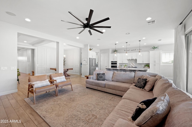 living room with recessed lighting, ceiling fan, visible vents, and light wood-style flooring