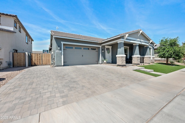view of front of house with a garage, a gate, stucco siding, and decorative driveway