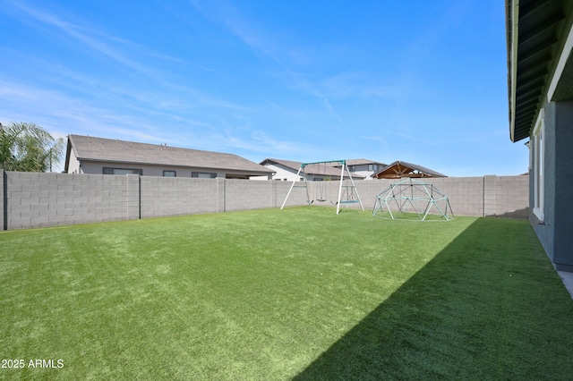 view of yard with a fenced backyard and a playground