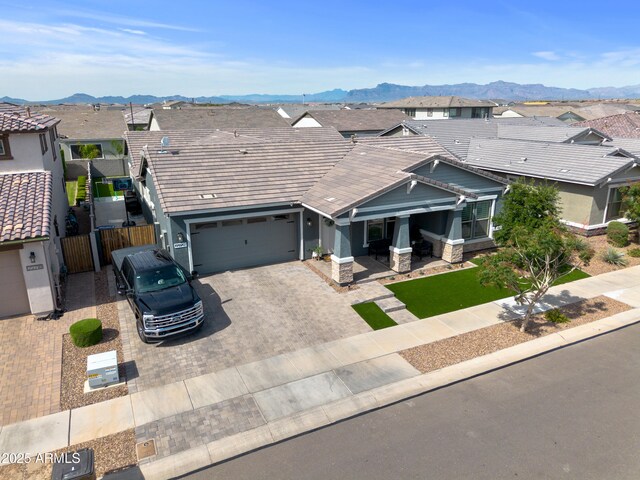 view of front of house with decorative driveway, a residential view, and a mountain view