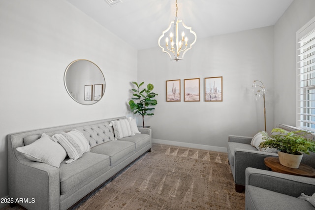 living room featuring carpet floors, baseboards, a notable chandelier, and visible vents