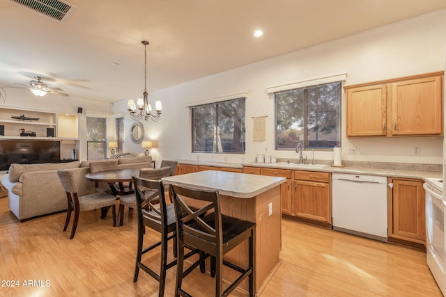 kitchen featuring white appliances, light hardwood / wood-style floors, a kitchen island, and hanging light fixtures