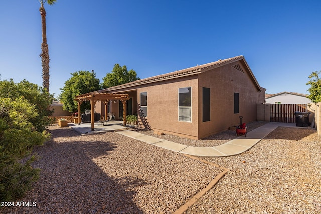 rear view of property featuring a pergola and a patio