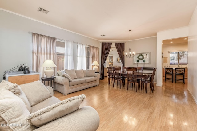 living room featuring a notable chandelier, light hardwood / wood-style floors, and crown molding