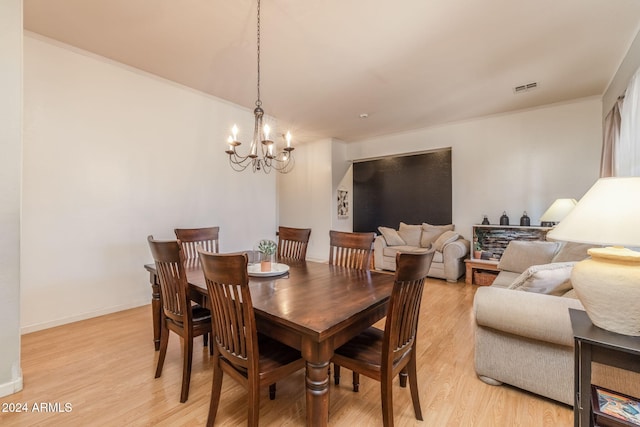 dining room featuring light wood-type flooring and an inviting chandelier