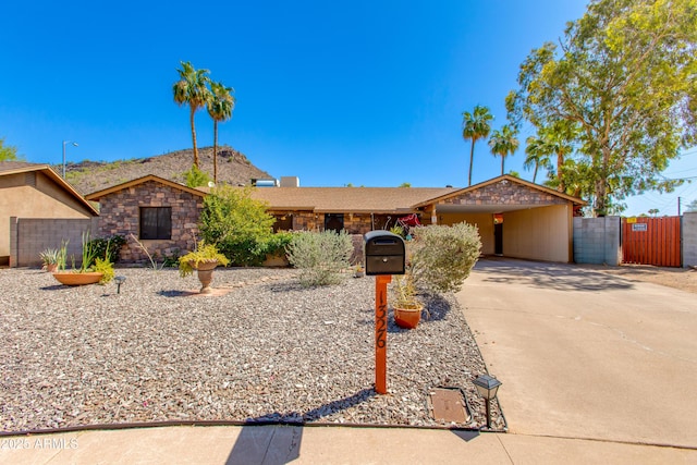 1326 W Joan De Arc Ave, Phoenix, AZ 85029 - ranch-style house featuring stone siding, driveway, a gate, and a carport