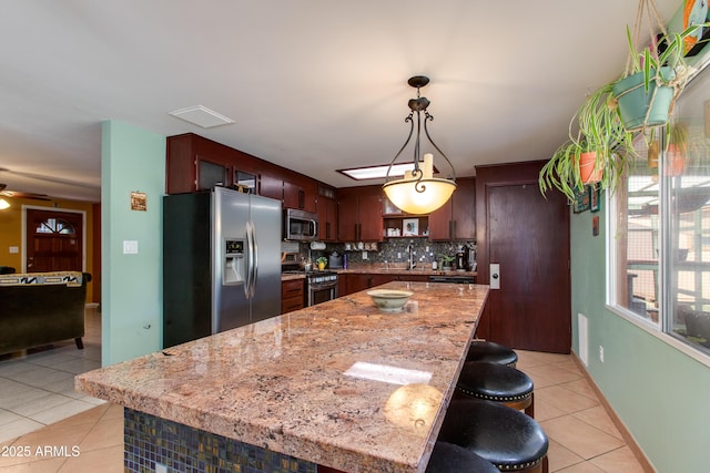 1326 W Joan De Arc Ave, Phoenix, AZ 85029 - kitchen with stainless steel appliances, light tile patterned flooring, backsplash, ceiling fan, and decorative light fixtures