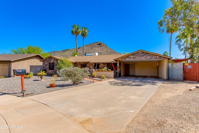 1326 W Joan De Arc Ave, Phoenix, AZ 85029 - ranch-style home featuring stone siding, concrete driveway, a mountain view, and a gate