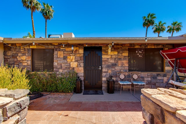 1326 W Joan De Arc Ave, Phoenix, AZ 85029 - view of exterior entry featuring stone siding and a patio area
