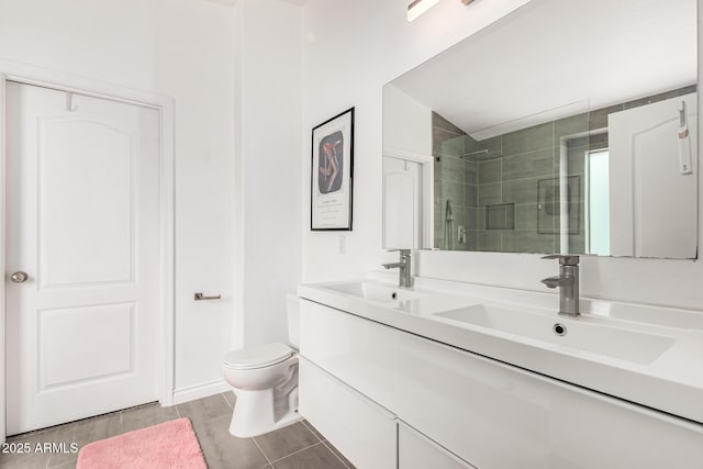 full bathroom featuring double vanity, a shower stall, toilet, and a sink