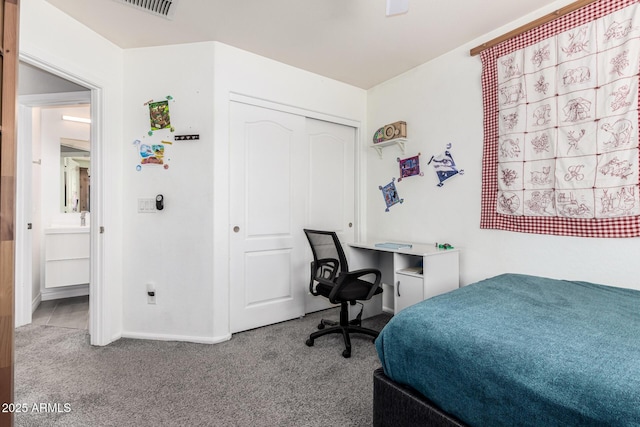 carpeted bedroom with a closet and baseboards