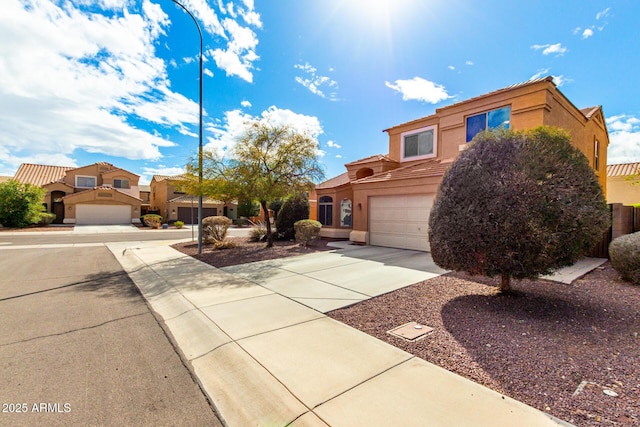 view of front of home featuring driveway, an attached garage, stucco siding, a tiled roof, and a residential view