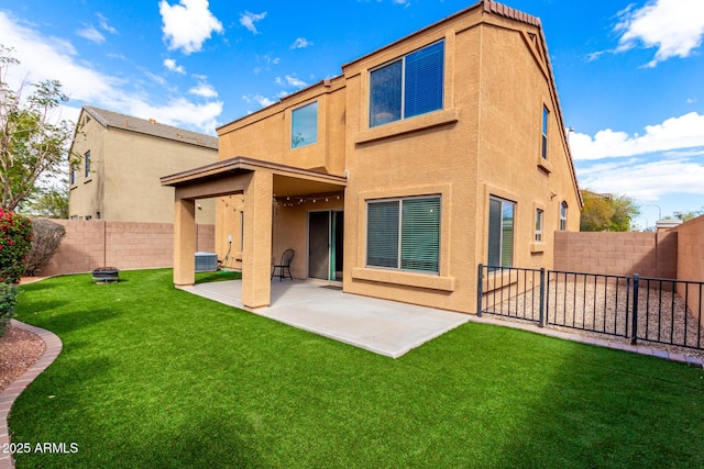 back of property with a patio area, stucco siding, a yard, and a fenced backyard