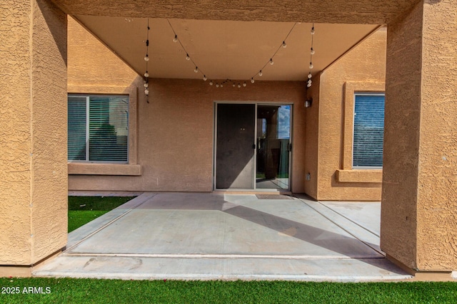 doorway to property with a patio area and stucco siding