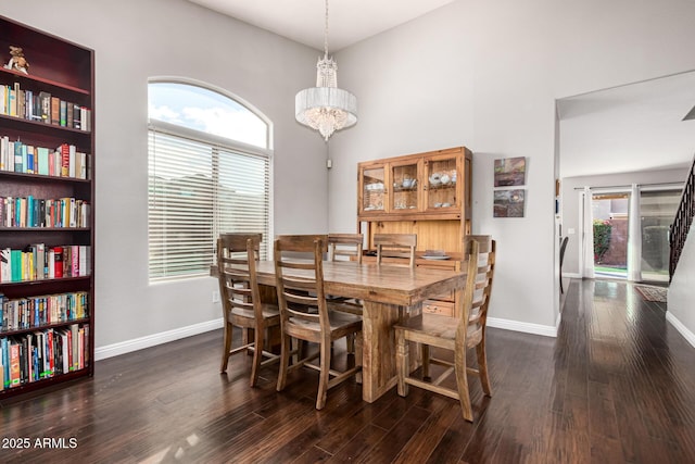 dining space featuring dark wood finished floors, a chandelier, a healthy amount of sunlight, and baseboards