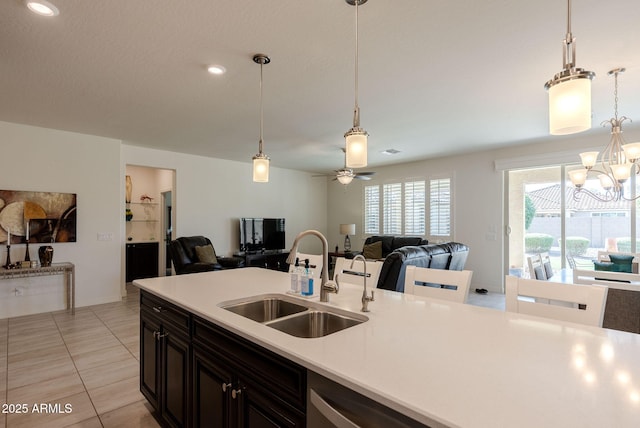 kitchen with open floor plan, light countertops, a sink, and pendant lighting