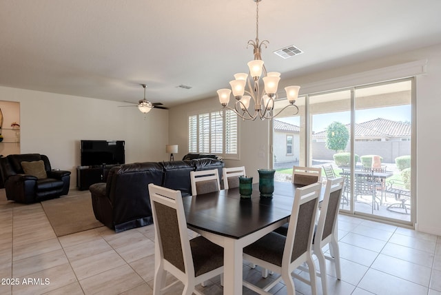 dining area with light tile patterned floors, ceiling fan with notable chandelier, and visible vents