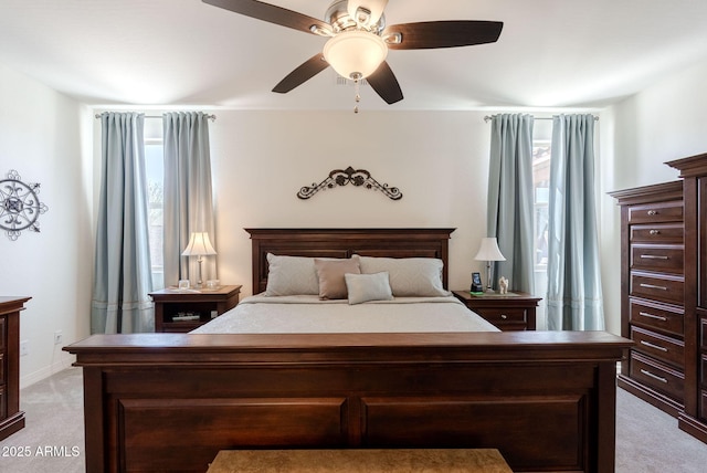 bedroom featuring light colored carpet, baseboards, and a ceiling fan