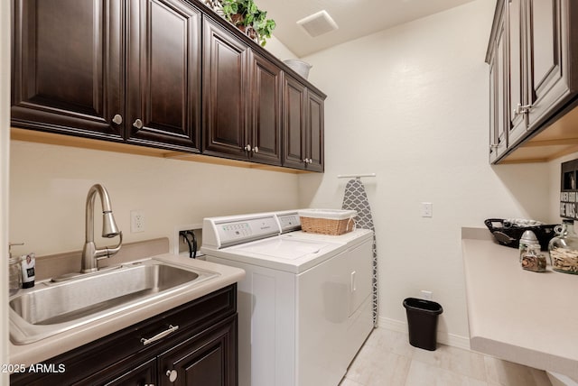 laundry area with visible vents, independent washer and dryer, baseboards, a sink, and cabinet space