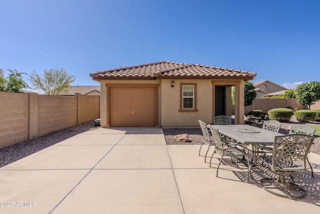 exterior space with a fenced backyard, driveway, and outdoor dining space