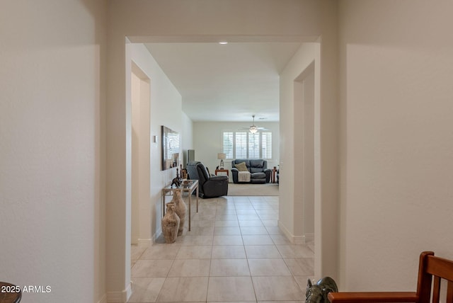 corridor with baseboards and light tile patterned floors