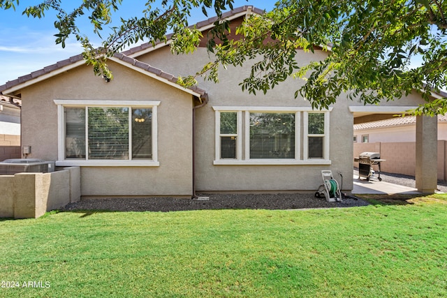 rear view of property with a patio, a lawn, and central AC unit