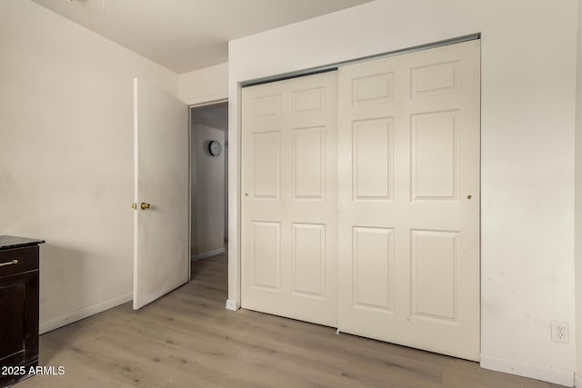 unfurnished bedroom featuring a closet and light hardwood / wood-style flooring