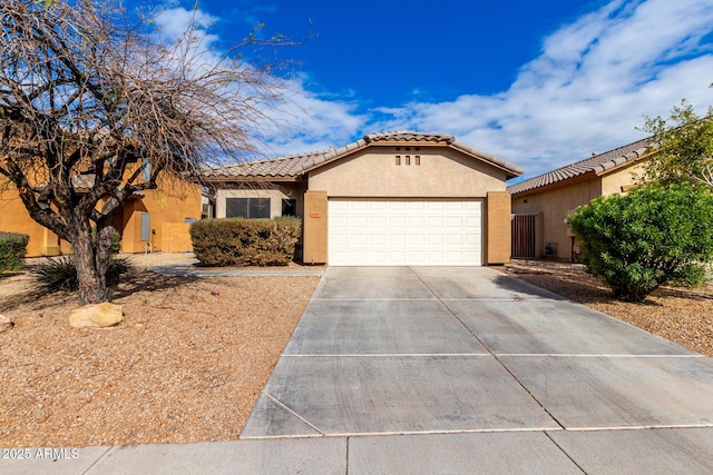 view of front of house with a tiled roof, stucco siding, concrete driveway, and a garage