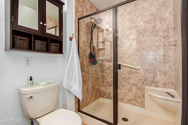 bathroom with a shower with shower door and toilet