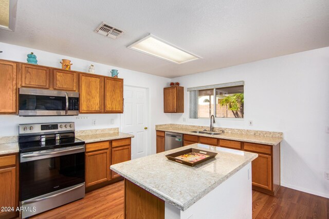 kitchen with a center island, wood-type flooring, sink, and appliances with stainless steel finishes