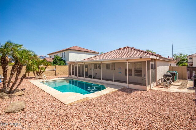 view of swimming pool featuring a patio and a sunroom