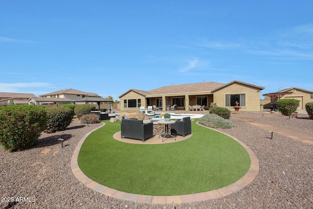 back of house with stucco siding, an outdoor living space, and a patio