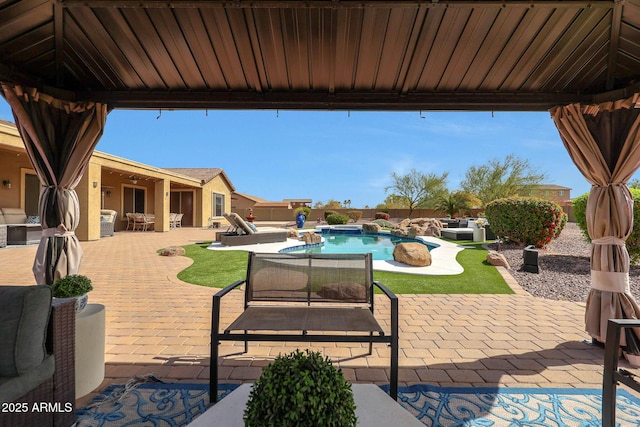 view of patio featuring a gazebo, outdoor lounge area, fence, and a fenced in pool